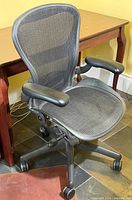 Full view of Herman Miller Aeron chair showing mesh seat/back, armrests, base