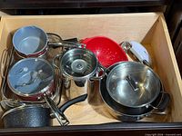 Top view of drawer showing entire assortment of pots, pans, colander, mixer