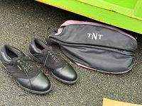 Shoes and carry bag laid out side by side on pavement