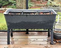 Front view of raised wicker-look planter showing overall design and legs