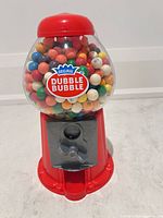 Front view of red Dubble Bubble gumball machine filled with gumballs