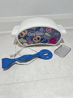 Easy-Bake toy oven, pan and spatula laid out on floor