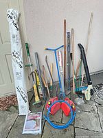 All items grouped against wall showing variety of tools, blower, levels, fuel cans, fabric and mesh
