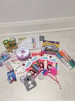 Full lot overview displaying bracelet maker, beads, hair tinsel, watercolor set, sunglasses, jewelry pieces, snacks