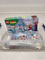 Overall lot showing box, plastic tote with bagged and loose Duplo pieces