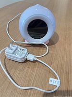 Front view of LittleHippo alarm clock and AC adapter with USB cable