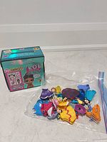 Overall lot showing LOL Surprise box and bag of Disney Princess dolls and accessories