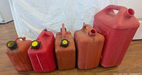 Five gas cans lined up left to right showing relative sizes and missing caps
