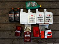 All eight items laid out: motor oil, ATF bottles, manual transmission fluid bottles, two FRAM oil filters with boxes