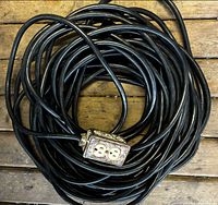 Coiled black heavy-duty extension cord with metal duplex outlet box