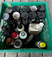 Top-down view of green crate containing multiple grease cartridges and assorted fluid containers