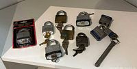 Overview of all ten locks including blister-pack padlock, loose laminated and brass padlocks, and rod lock