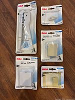 All five packaged RCA phone accessories on floor