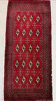 Full view of red Turkman mat rug showing overall pattern and size