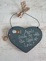 Front of painted wooden heart plaque with angel graphic and text