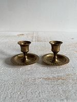 Pair of brass candlestick holders front view