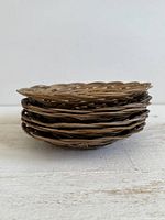 Stack of six shallow round wicker baskets, side view