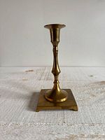 Front view of brass candlestick showing full height and square base