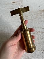 Brass corkscrew held in hand showing size and side detail