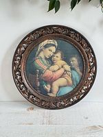 Front view showing Madonna with Child print and pierced copper-tone frame