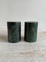 Front view of both cylindrical green stone shakers