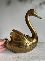 Left profile of brass swan planter showing feather detailing and size reference