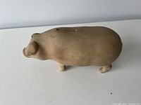side view of terracotta pig bank showing overall form and slot