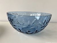 side profile of blue glass bowl showing cut leaf motif