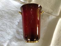 Full view of burgundy Carlton Ware vase with gold handles and foot