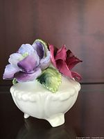 Front view of multicolor bone china flower bouquet in white footed vase