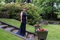 Model wearing navy gown front view on garden steps