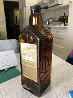 Full view of amber glass Nyhavn decanter showing molded building design and cap