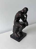 Front-left view of bronze-finish The Thinker sculpture on square base