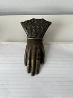 Top view of brass hand-shaped clip clasping notebook page