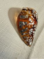 Front view of glass leaf pendant showing color pattern and foil inclusions