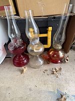 Image shows all three glass hurricane lamps standing side by side