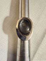 Front view of silver-tone mood ring on mandrel showing oval stone and size marks