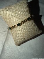 Bracelet displayed on burlap cushion showing link and stone design