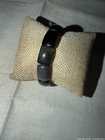 Full view of black stone stretch bracelet on display cushion