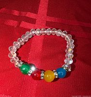 Bracelet laid flat showing clear beads and four coloured centre beads