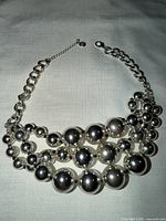 Full view of necklace laid flat showing multi-strand bead arrangement and chain