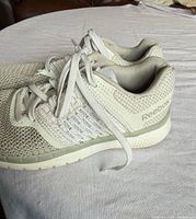 left side view of both Reebok sneakers showing mesh uppers, laces, side branding