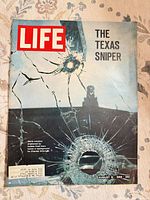 Front cover with title, date and bullet-holed glass image