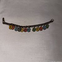 Full view of silvertone chain bracelet with multicolour enamel letter charms spelling Niagara Falls