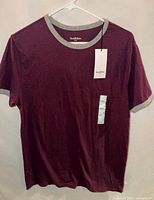 Front view of burgundy ringer T-shirt on hanger