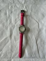 Front view of Ecclissi wristwatch laid flat showing full strap and dial