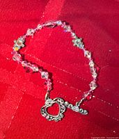 Bracelet close-up showing beads and heart clasp