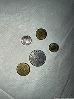 five coins on cloth, obverse sides visible