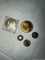 All five coins arranged on cloth surface