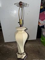 Full view of tall cream ceramic lamp on floor